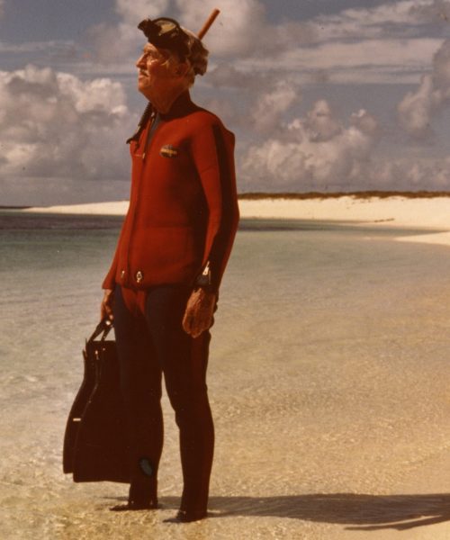 Marlin Perkins in red scuba gear, on Laysan Island, preparing to snorkel with monk seals in 1977. [Marlin Perkins Papers (S0516)]